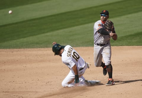 Donovan Solano #7 of the SF Giants completes the double-play throwing over the top of Marcus Semien #10 of the Oakland Athletics in the bottom of the sixth inning at RingCentral Coliseum on September 19, 2020. (Photo by Thearon W. Henderson/Getty Images)