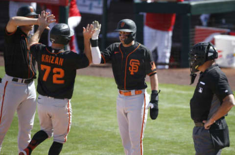 TEMPE, ARIZONA – MARCH 11: Mauricio Dubon #1 of the SF Giants (C) look to the home plate umpire as he congratulates Jason Krizan #72 of the Giants after they score against the Los Angeles Angels during the first inning of the MLB spring training baseball game at Tempe Diablo Stadium on March 11, 2021 in Tempe, Arizona. (Photo by Ralph Freso/Getty Images)