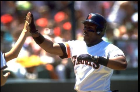 1990: SAN FRANCISCO GIANTS OUTFIELDER KEVIN MITCHELL RECEIVES WELCOME AT HOME PLATE AFTER SCORING IN GIANTS GAME AT CANDLESTICK PARK IN SAN FRANCISCO, CALIFORNIA.