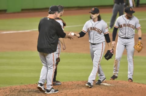 MIAMI, FL – JUNE 12: Cory Gearrin #26 of the San Francisco Giants hands the baseball to manager Bruce Bochy #15 after being taken out in the eighth inning against the Miami Marlins at Marlins Park on June 12, 2018 in Miami, Florida. (Photo by Eric Espada/Getty Images)