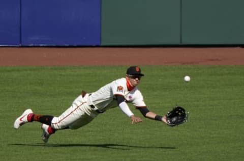 SAN FRANCISCO, CALIFORNIA – AUGUST 16: Mauricio Dubon #1 of the SF Giants makes a diving catch taking a hit away from Vimael Machin #39 of the Oakland Athletics in the top of the ninth inning at Oracle Park on August 16, 2020 in San Francisco, California. The Athletics won the game 15-3. (Photo by Thearon W. Henderson/Getty Images)