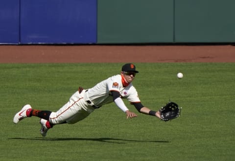 Mauricio Dubón #1 of the SF Giants makes a diving catch taking a hit away from Vimael Machin #39 of the Oakland Athletics in the top of the ninth inning at Oracle Park on August 16, 2020 in San Francisco, California. The Athletics won the game 15-3. (Photo by Thearon W. Henderson/Getty Images)