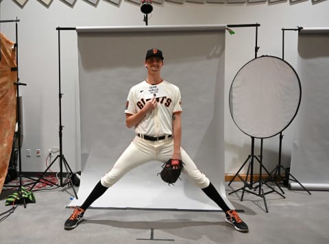 SF Giants pitcher Sean Hjelle (84), who is 6’11’ helps out photographers so he so he fits in the seamless backdrop during spring training media day at Scottsdale Stadium. (Jayne Kamin-Oncea-USA TODAY Sports)