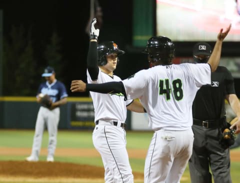 Eugene Emeralds Will Wilson (center) celebrates his 8th inning home run with Frank Labour at PK Park in Eugene.