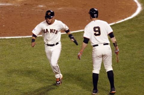 Oct 7, 2014; San Francisco, CA, USA; San Francisco Giants second baseman Joe Panik (left) is congratulated by first baseman Brandon Belt (9) after scoring on a wild pitch during the seventh inning of game four of the 2014 NLDS baseball playoff game against the Washington Nationals at AT&T Park. Mandatory Credit: Kelley L Cox-USA TODAY Sports