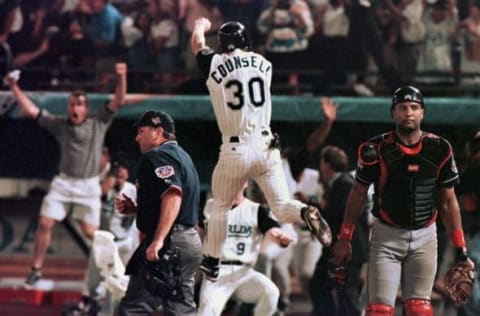 Florida Marlins player Craig Counsell jumps in the air after crossing the plate with the winning run as Cleveland Indians catcher Sandy Alomar (R) walks off the field at the end of game seven of the World Series 26 October at Pro Player Stadium. The Marlins won in 11 innings 3-2. AFP PHOTO/Jeff HAYNES (Photo by JEFF HAYNES / AFP) (Photo credit should read JEFF HAYNES/AFP via Getty Images)