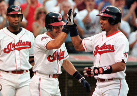 Cleveland Indians slugger Manny Ramirez (R) is congratulated at the plate by teammate Omar Vizquel (C) after he hit a grand slam during the first inning 24 June at Jacobs Field in Cleveland, OH. At left is Indians catcher Sandy Alomar. AFP/Anthony ONCHAK (Photo by ANTHONY ONCHAK / AFP) (Photo by ANTHONY ONCHAK/AFP via Getty Images)