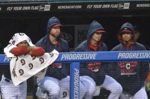 Aug 26, 2015; Cleveland, OH, USA; Cleveland Indians third baseman Jose Ramirez (from left), starting pitcher Corey Kluber (28), starting pitcher Josh Tomlin (43) and starting pitcher Carlos Carrasco (59) watch in the rain in the first inning against the Milwaukee Brewers at Progressive Field. Mandatory Credit: David Richard-USA TODAY Sports