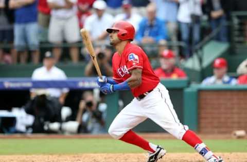 Oct 7, 2016; Arlington, TX, USA; Texas Rangers center fielder Ian Desmond (20) hits an RBI sacrifice ground ball against the Toronto Blue Jays during the eighth inning of game two of the 2016 ALDS playoff baseball series at Globe Life Park in Arlington. Mandatory Credit: Kevin Jairaj-USA TODAY Sports