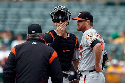 OAKLAND, CA – MAY 06: Alex Cobb #17 of the Baltimore Orioles talk to Caleb Joseph #36 and pitching coach Roger McDowell #40 during a mound visit in the sixth inning against the Oakland Athletics at the Oakland Coliseum on May 6, 2018 in Oakland, California. The Oakland Athletics defeated the Baltimore Orioles 2-1. (Photo by Jason O. Watson/Getty Images)