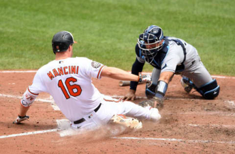 BALTIMORE, MD – JULY 28: Trey Mancini #16 of the Baltimore Orioles beats the tag by Rene Pinto for an inside the park home in the eight inning during a baseball game at Oriole Park at Camden Yards on July 28, 2022 in Baltimore, Maryland. (Photo by Mitchell Layton/Getty Images)