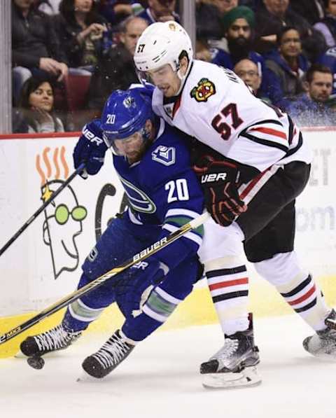 Mar 27, 2016; Vancouver, British Columbia, CAN; Chicago Blackhawks defenseman Trevor Van Riemsdyk (57) checks Vancouver Canucks forward Chris Higgins (20) during the first period at Rogers Arena. Mandatory Credit: Anne-Marie Sorvin-USA TODAY Sports