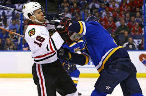 Apr 15, 2016; St. Louis, MO, USA; Chicago Blackhawks left wing Andrew Ladd (16) is checked by St. Louis Blues defenseman Carl Gunnarsson (4) during the first period in game two of the first round of the 2016 Stanley Cup Playoffs at Scottrade Center. Mandatory Credit: Billy Hurst-USA TODAY Sports