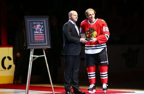 Jan 3, 2016; Chicago, IL, USA; Chicago Blackhawks general manager Stan Bowman presents right wing Patrick Kane (right) with a golden puck to commemorate Kane