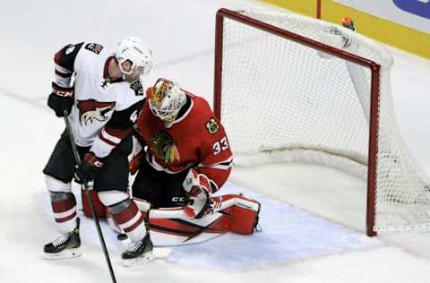 Apr 5, 2016; Chicago, IL, USA; Arizona Coyotes left wing Jordan Martinook (48) and Chicago Blackhawks goalie Scott Darling (33) fight for a puck in the third period at the United Center. Mandatory Credit: Matt Marton-USA TODAY Sports