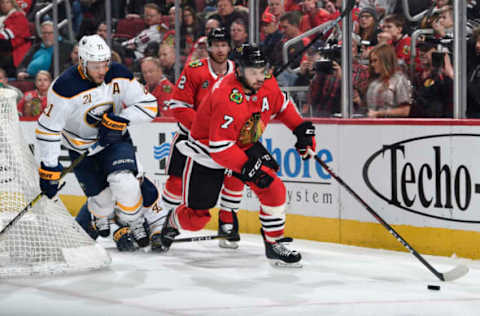 CHICAGO, IL – MARCH 07: Brent Seabrook #7 of the Chicago Blackhawks grabs the puck ahead of Kyle Okposo #21 of the Buffalo Sabres in the second period at the United Center on March 7, 2019 in Chicago, Illinois. (Photo by Bill Smith/NHLI via Getty Images)