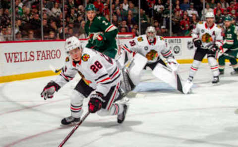 ST. PAUL, MN – OCTOBER 11: Henri Jokiharju #28 of the Chicago Blackhawks skates with the puck in front of Cam Ward #30 of the Chicago Blackhawks as Charlie Coyle #3 of the Minnesota Wild defends during a game between the Minnesota Wild and Chicago Black Hawks at Xcel Energy Center on October 11, 2018 in St. Paul, Minnesota. The Wild defeated the Black Hawks 4-3 in overtime.(Photo by Bruce Kluckhohn/NHLI via Getty Images)