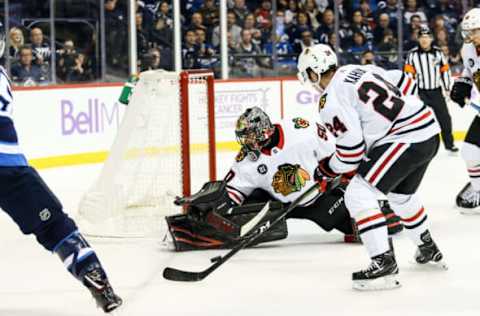 WINNIPEG, MB – NOVEMBER 29: Chicago Blackhawks goalie Corey Crawford (50) stops Winnipeg Jets forward Mark Scheifele (55) during the regular season game between the Winnipeg Jets and the Chicago Blackhawks on November 29, 2018, at the Bell MTS Place in Winnipeg MB. (Photo by Terrence Lee/Icon Sportswire via Getty Images)