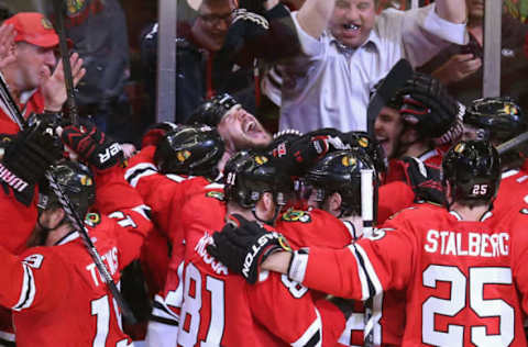 CHICAGO, IL – MAY 29: Brent Seabrook #7 of the Chicago Blackhawks (center) yells as teammates join him in celebration after he scored the winning goal in overtime against against the Detroit Red Wings in Game Seven of the Western Conference Semifinals during the 2013 NHL Stanley Cup Playoffs at the United Center on May 29, 2013 in Chicago, Illinois. The Blackhawks defeated the Red Wings 2-1 in overtime. (Photo by Jonathan Daniel/Getty Images)