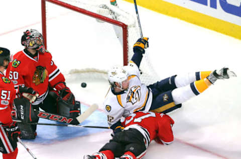 Apr 15, 2017; Chicago, IL, USA; Nashville Predators center Ryan Johansen (92) scores past Chicago Blackhawks goalie Corey Crawford (50) and lands on defenseman Trevor van Riemsdyk (57) during the third period in game two of the first round of the 2017 Stanley Cup Playoffs at the United Center. Nashville won 5-0. Mandatory Credit: Dennis Wierzbicki-USA TODAY Sports