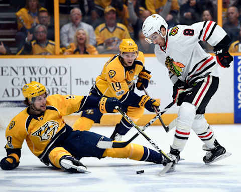 Apr 17, 2017; Nashville, TN, USA; Nashville Predators left wing Filip Forsberg (9) battles for a loose puck after being hit by Chicago Blackhawks center Nick Schmaltz (8) during the first period in game three of the first round of the 2017 Stanley Cup Playoffs at Bridgestone Arena. Mandatory Credit: Christopher Hanewinckel-USA TODAY Sports