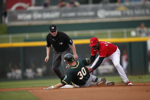 GOODYEAR, AZ – February 28: Alfredo Rodriguez #69 of the Cincinnati Reds tags Austin Allen #30 of the Oakland Athletics out at second. (Photo by Michael Zagaris/Oakland Athletics/Getty Images)