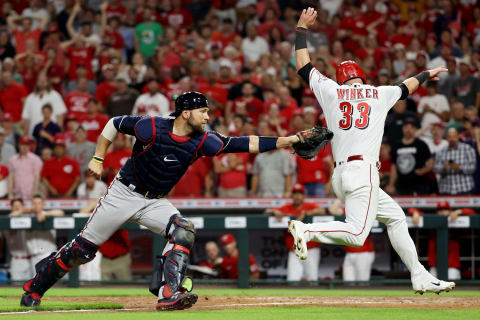 CINCINNATI, OHIO – JUNE 24: Kevan Smith #52 of the Atlanta Braves attempts to tag out Jesse Winker #33 of the Cincinnati Reds. (Photo by Dylan Buell/Getty Images)