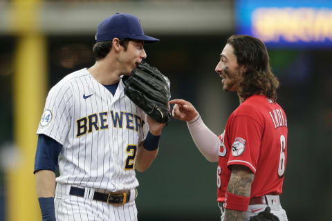 MILWAUKEE, WISCONSIN – JULY 11: Christian Yelich #22 of the Milwaukee Brewers talks with Jonathan India #6 of the Cincinnati Reds between innings. (Photo by John Fisher/Getty Images)