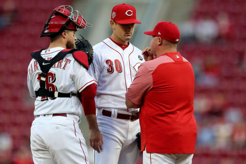 Cincinnati Reds pitching coach Derek Johnson (36) talks to Cincinnati Reds starting pitcher Tyler Mahle (30) and Cincinnati Reds catcher Tucker Barnhart (16) during a mound visit.