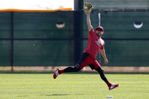 Cincinnati Reds outfielder Mark Payton (34) catches a fly ball during outfield drills.