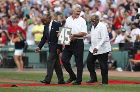 Jul 28, 2015; Boston, MA, USA; Former Red Sox players Tommy Harper (left), Dwight Evans and Luis Tiant present the number 45 from the green monster during Hall of Fame player Pedro Martinez (not pictured) number retirement ceremony before the game against the Chicago White Sox at Fenway Park. Mandatory Credit: Greg M. Cooper-USA TODAY Sports