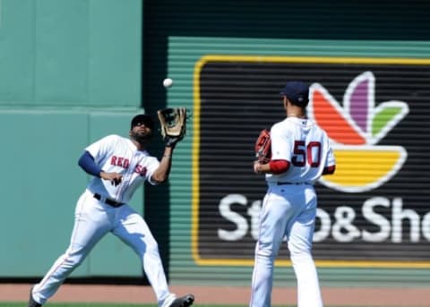 Jul 3, 2016; Boston, MA, USA; Boston Red Sox center fielder Jackie Bradley Jr. (25) makes a catch in front of right fielder Mookie Betts (50) during the fifth inning against the Los Angeles Angels at Fenway Park. Mandatory Credit: Bob DeChiara-USA TODAY Sports