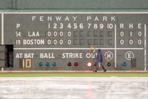 BOSTON, MA – MAY 4: A worker walks by the left field wall during a rain delay during the game between the Boston Red Sox and the Los Angeles Angels of Anaheim at Fenway Park on May 4, 2011 in Boston, Massachusetts. (Photo by Jim Rogash/Getty Images)