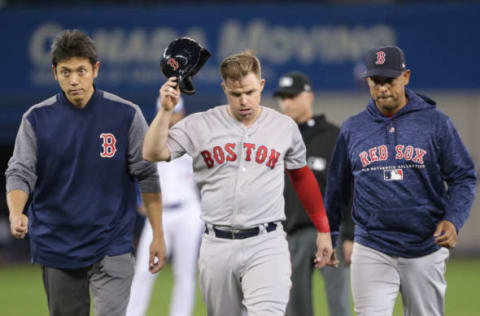 TORONTO, ON – APRIL 26: Brock Holt #12 of the Boston Red Sox exits the game after pulling his hamstring muscle running out a double as he is flanked by the trainer and manager Alex Cora #20 in the third inning during MLB game action against the Toronto Blue Jays at Rogers Centre on April 26, 2018 in Toronto, Canada. (Photo by Tom Szczerbowski/Getty Images)