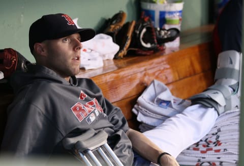 BOSTON – JULY 02: Dustin Pedroia #15 of the Boston Red Sox sits in the dugout with a broken foot as his teammates take on the Baltimore Orioles on July 2, 2010 at Fenway Park in Boston, Massachusetts. (Photo by Elsa/Getty Images)