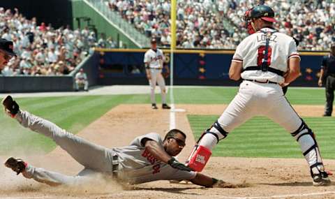 Boston Reds Sox Jose Offerman (L) slides past the tag of Atlanta Braves’ catcher Javy Lopez (R) to score on an eighth inning double and a two-base error 11 June 2000 at Turner Field in Atlanta, Georgia. The Reds Sox went on to beat the Braves 5-3. AFP PHOTO/STEVE SCHAEFER (Photo by STEVE SCHAEFER / AFP) (Photo credit should read STEVE SCHAEFER/AFP via Getty Images)