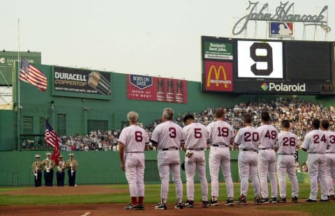 Members of the Boston Red Sox pay tribute to Ted Williams beneath a large number 9, Williams’ uniform number, during a ceremony prior to their game with the Detroit Tigers 05 July 2002 at Fenway Park in Boston, Massachusetts. Red Sox Hall of Famer Williams died 05 July 2002 at the age of 83. AFP PHOTO/JESSICA RINALDI (Photo by JESSICA RINALDI / AFP) (Photo credit should read JESSICA RINALDI/AFP via Getty Images)