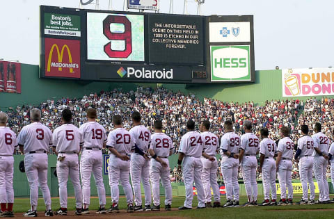 BOSTON, UNITED STATES: Members of the Boston Red Sox pay tribute to Ted Williams beneath a large number 9, Williams’ uniform number, during a ceremony prior to their game with the Detroit Tigers 05 July 2002 at Fenway Park in Boston, Massachusetts. Red Sox Hall of Famer legend Williams died 05 July 2002 at the age of 83. AFP PHOTO/JESSICA RINALDI (Photo credit should read JESSICA RINALDI/AFP via Getty Images)