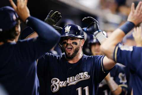 MIAMI, FLORIDA – SEPTEMBER 11: Mike Moustakas #11 of the Milwaukee Brewers celebrates with teammates in the dugout after hitting a three-run home run in the third inning against the Miami Marlins at Marlins Park on September 11, 2019 in Miami, Florida. (Photo by Michael Reaves/Getty Images)