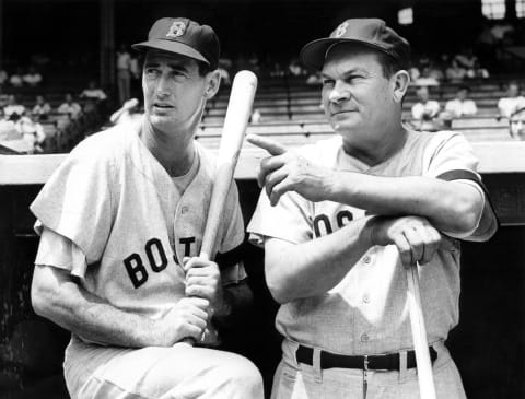 CLEVELAND – 1956: (l to r) Outfielder Ted Williams and manager Pinky Higgins of the Boston Red Sox pose on the dugout steps prior to a 1956 season game between the Red Sox and the Cleveland Indians at Municipal Stadium in Cleveland, Ohio. (Photo by Ron Kuntz Collection/Diamond Images/Getty Images)