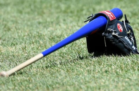 Apr 16, 2016; Boston, MA, USA; The glove and bat of Toronto Blue Jays first base coach Tim Leiper (34) rests on the grass prior to a game against the Boston Red Sox at Fenway Park. Mandatory Credit: Bob DeChiara-USA TODAY Sports