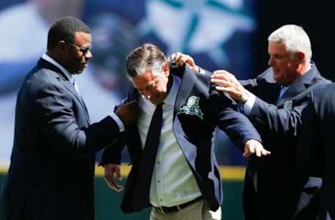 Aug 8, 2015; Seattle, WA, USA; Former Seattle Mariners Ken Griffey Jr. (left) and Lou Piniella (right) help pitcher Jamie Moyer into his new Mariners Hall of Fame jacket before the start of a game against the Texas Rangers at Safeco Field. Mandatory Credit: Jennifer Buchanan-USA TODAY Sports