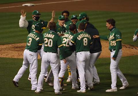 Sep 9, 2020; Oakland, California, USA; Teammates surround Oakland Athletics center fielder Ramon Laureano (22) after hitting an RBI single for a walk-off win against the Houston Astros during the ninth inning at Oakland Coliseum. Mandatory Credit: Kelley L Cox-USA TODAY Sports