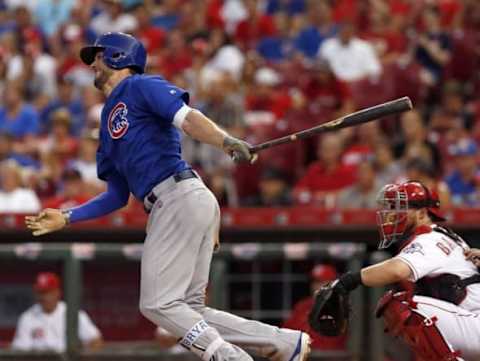 Jun 27, 2016; Cincinnati, OH, USA; Chicago Cubs third baseman Kris Bryant (L) hits a double against the Cincinnati Reds during the sixth inning at Great American Ball Park. Reds catcher Tucker Barnhart (16) watches at right. Mandatory Credit: David Kohl-USA TODAY Sports