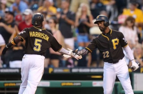 Sep 10, 2016; Pittsburgh, PA, USA; Pittsburgh Pirates second baseman Josh Harrison (5) crosses home plate to score a run and is greeted by center fielder Andrew McCutchen (22) against the Cincinnati Reds during the first inning at PNC Park. Mandatory Credit: Charles LeClaire-USA TODAY Sports