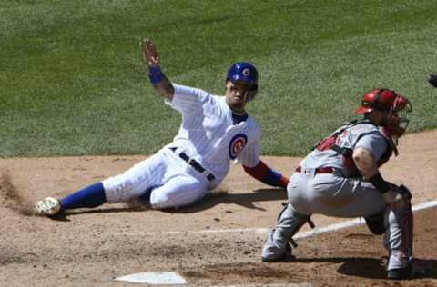 May 18, 2017; Chicago, IL, USA; Chicago Cubs second baseman Javier Baez (9) slides safely at home plate as Cincinnati Reds catcher Tucker Barnhart (16) waits for the throw during the fifth inning at Wrigley Field. Mandatory Credit: David Banks-USA TODAY Sports