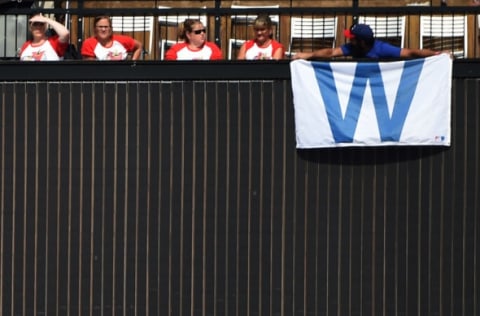 Sep 14, 2016; St. Louis, MO, USA; A Chicago Cubs fans holds his win sign as St. Louis Cardinals fans look on during the ninth inning at Busch Stadium. The Cubs won 7-0. Mandatory Credit: Jeff Curry-USA TODAY Sports