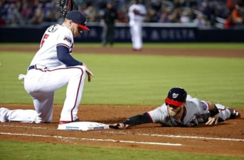 Apr 6, 2016; Atlanta, GA, USA; Washington Nationals right fielder Bryce Harper (34) dives back to first base on a pick off attempt by Atlanta Braves first baseman Freddie Freeman (5) in the fourth inning of their game at Turner Field. Mandatory Credit: Jason Getz-USA TODAY Sports