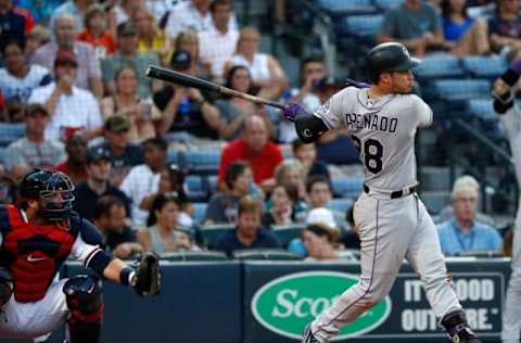 Jul 15, 2016; Atlanta, GA, USA; Colorado Rockies third baseman Nolan Arenado (28) hits an RBI single as Atlanta Braves catcher A.J. Pierzynski (15) is shown on the play in the third inning of their game at Turner Field. Mandatory Credit: Jason Getz-USA TODAY Sports