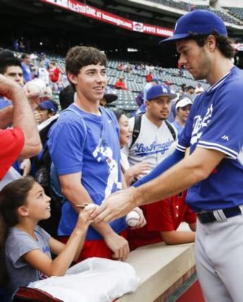 Jun 16, 2015; Arlington, TX, USA; Los Angeles Dodgers pitcher Josh Ravin, right, signs autographs for fans before a baseball game against the Texas Rangers at Globe Life Park in Arlington. Mandatory Credit: Jim Cowsert-USA TODAY Sports